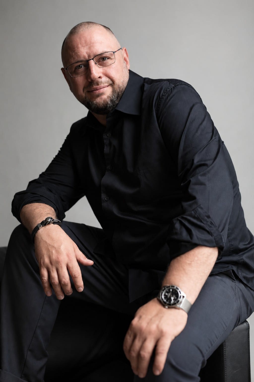 Александр Корвин сидит и улыбается